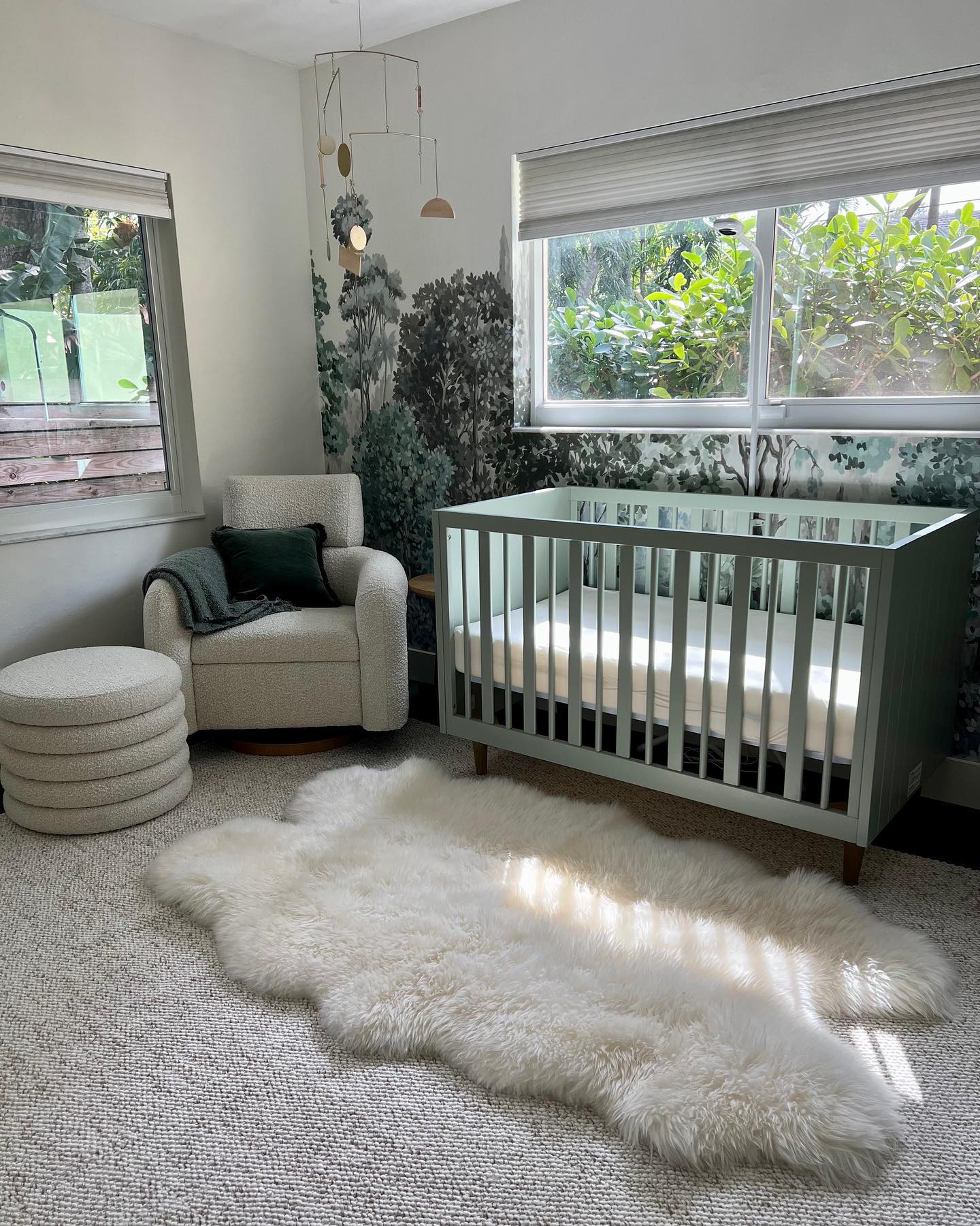 11. Sage Green Crib with Whimsical Rainbow Mobile In a Sunlit Nursery