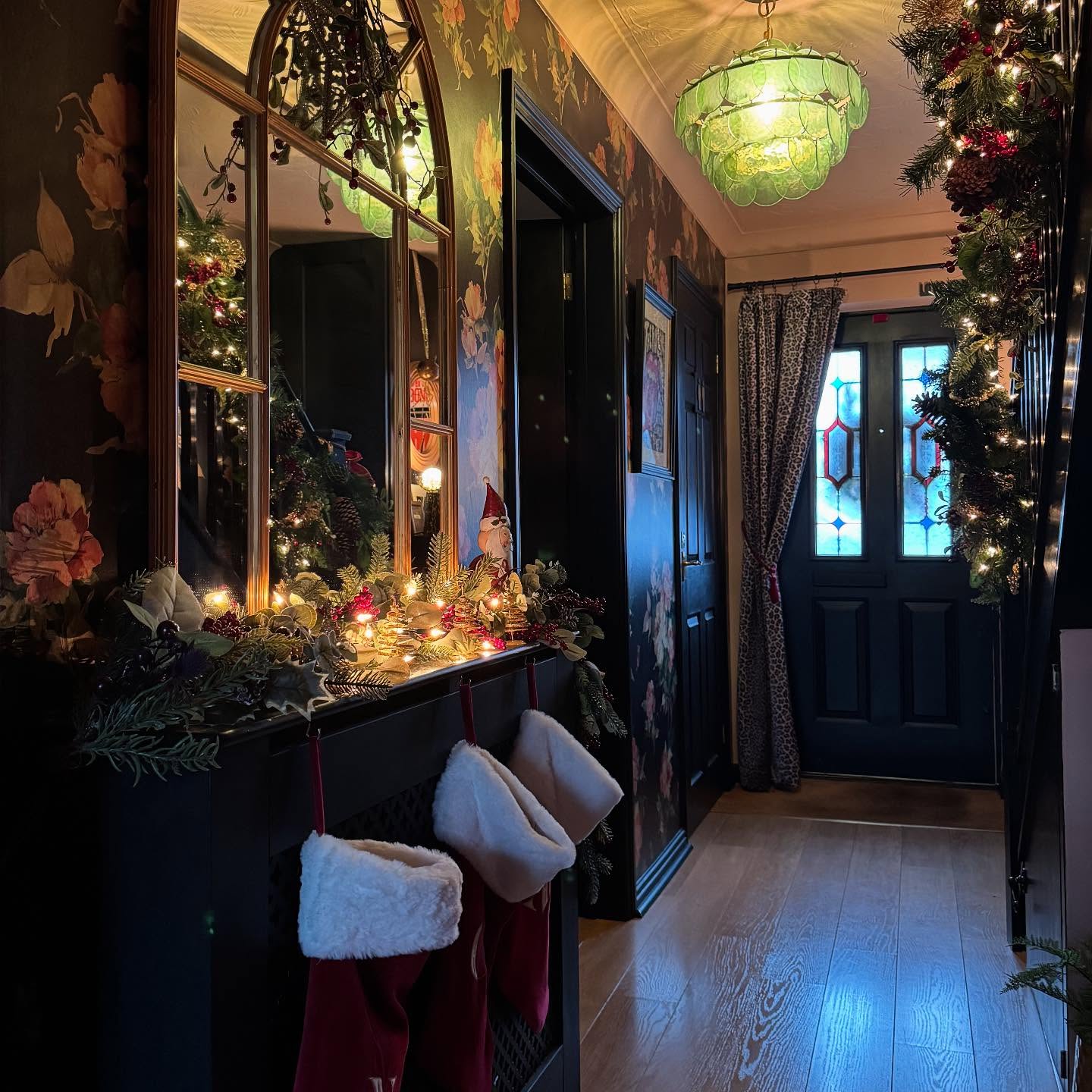 16. Crimson Ribbons and Golden Baubles Cascade Down a Frosted Archway