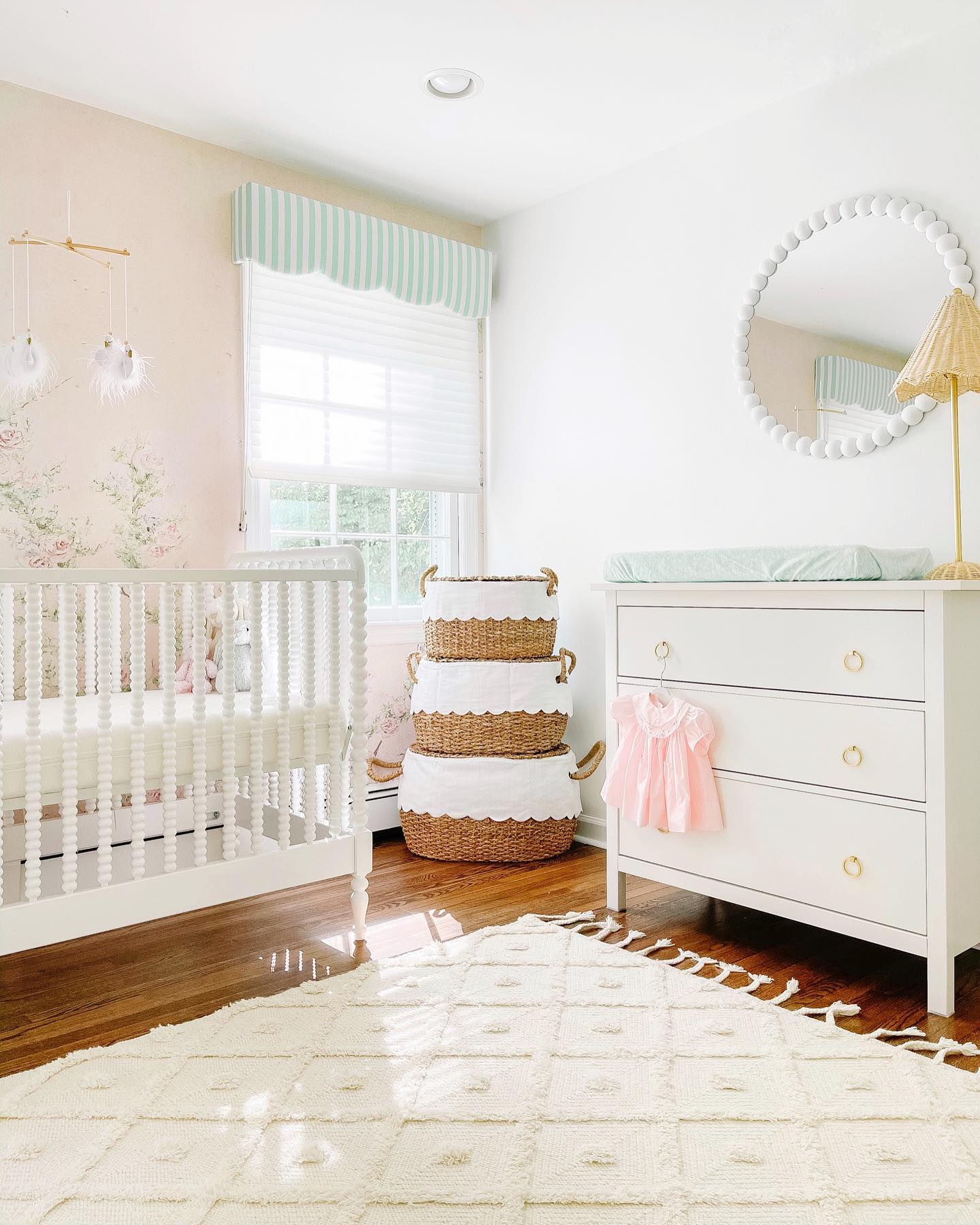 20. Vibrant Floral Wallpaper Meets Soft Pastel Crib In a Cozy Nook