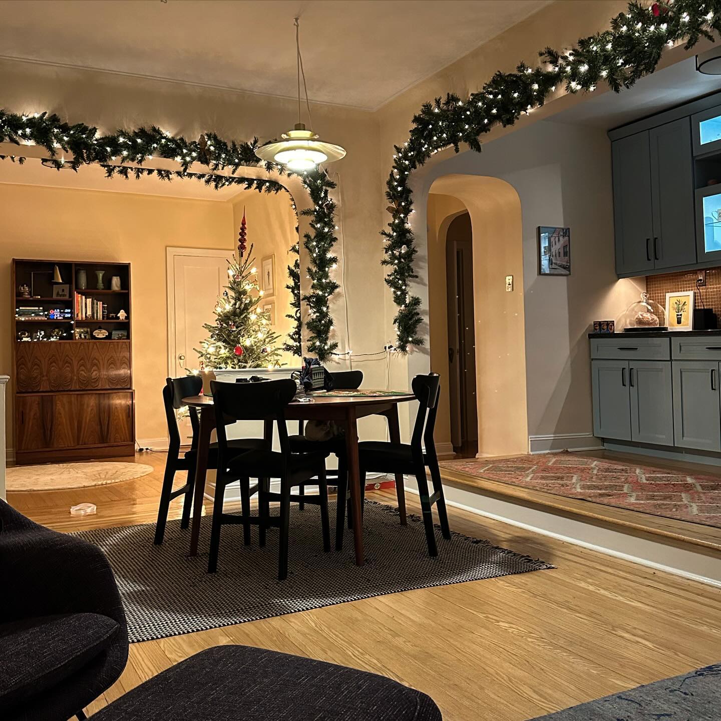 19. Festive Foliage Cascade Over Vintage Bookshelves In a Cozy Corner