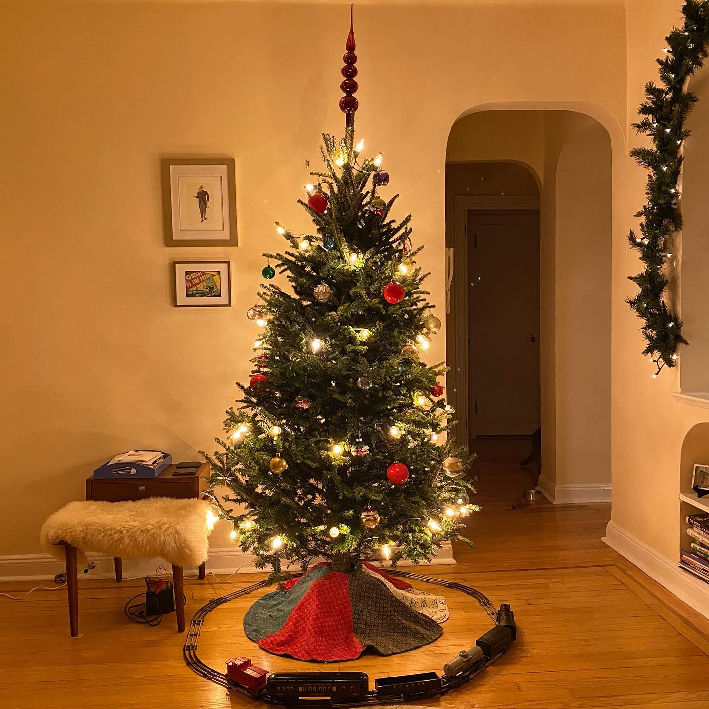 4. Festive Miniature Village on a Floating Bookshelf with a Glowing Star Garland