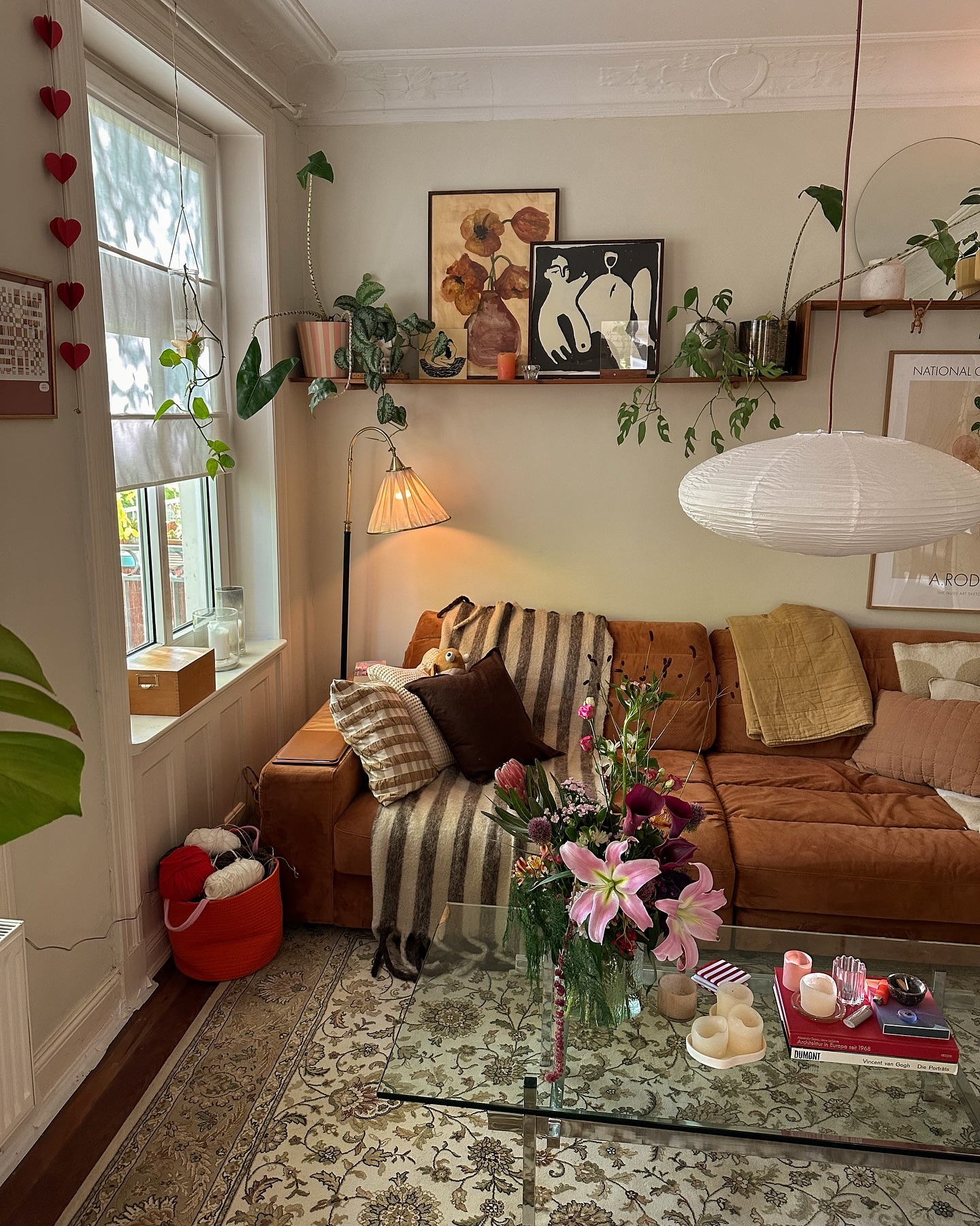 30. Cozy Nook with a Floating Bookcase and Geometric Wall Art Above a Deep Blue Velvet Sofa