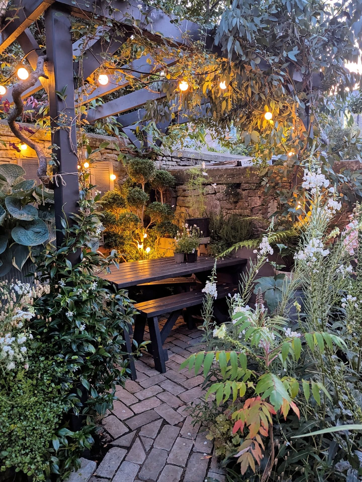 26. Tiny Oasis: a Circular Stone Path and Wooden Archway In a Compact Garden