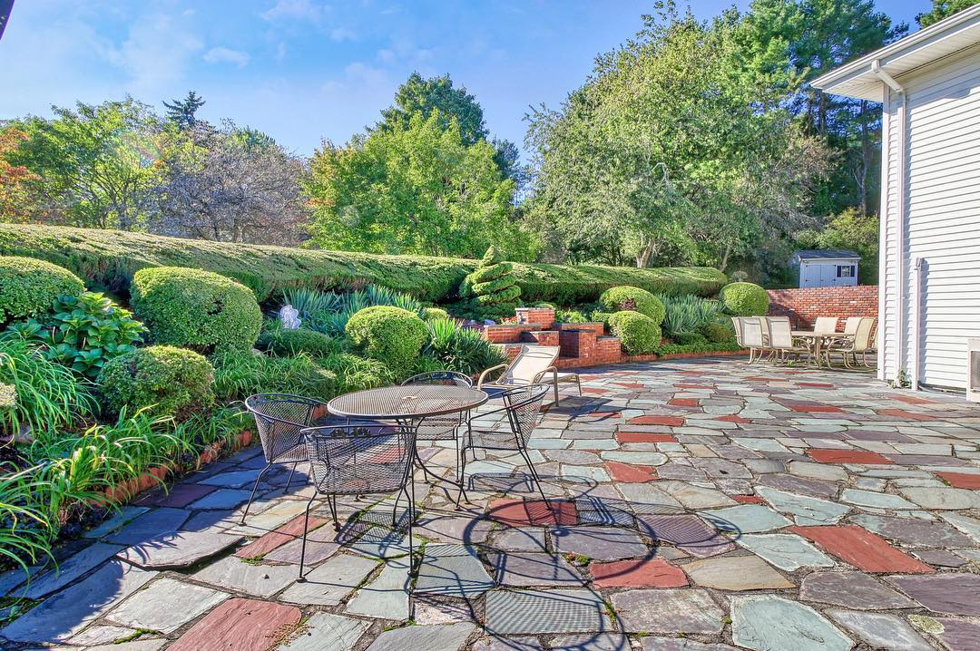 24. Flagstone Patio with a Circular Fire Pit and Lush Green Surround