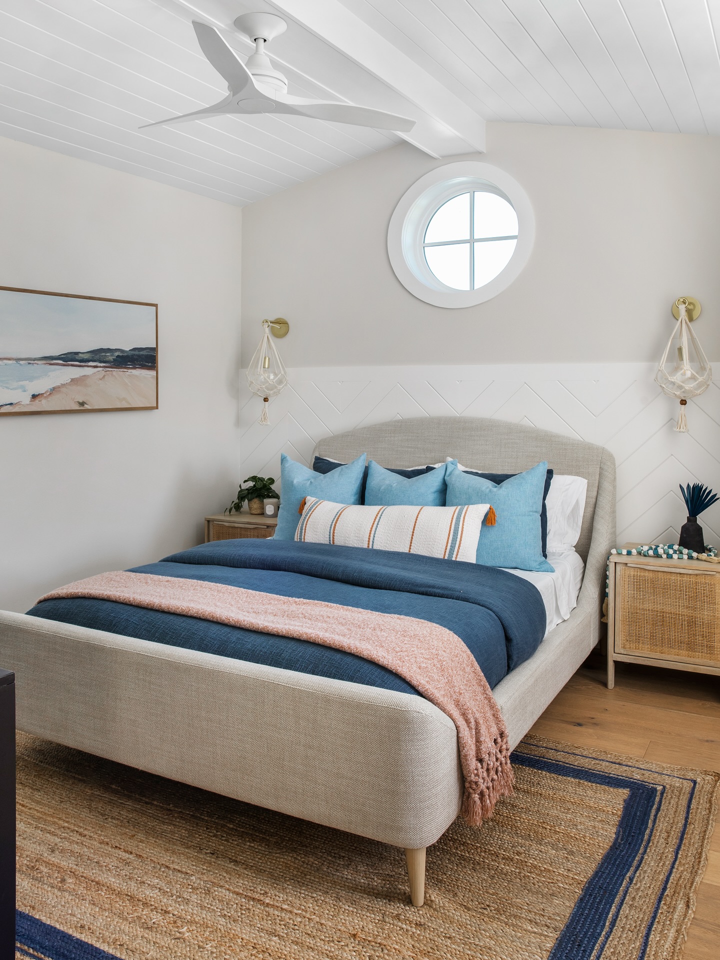 29. Coastal Breeze Meets Vintage Charm: a Bedroom with a Wicker Headboard and Porthole Mirror