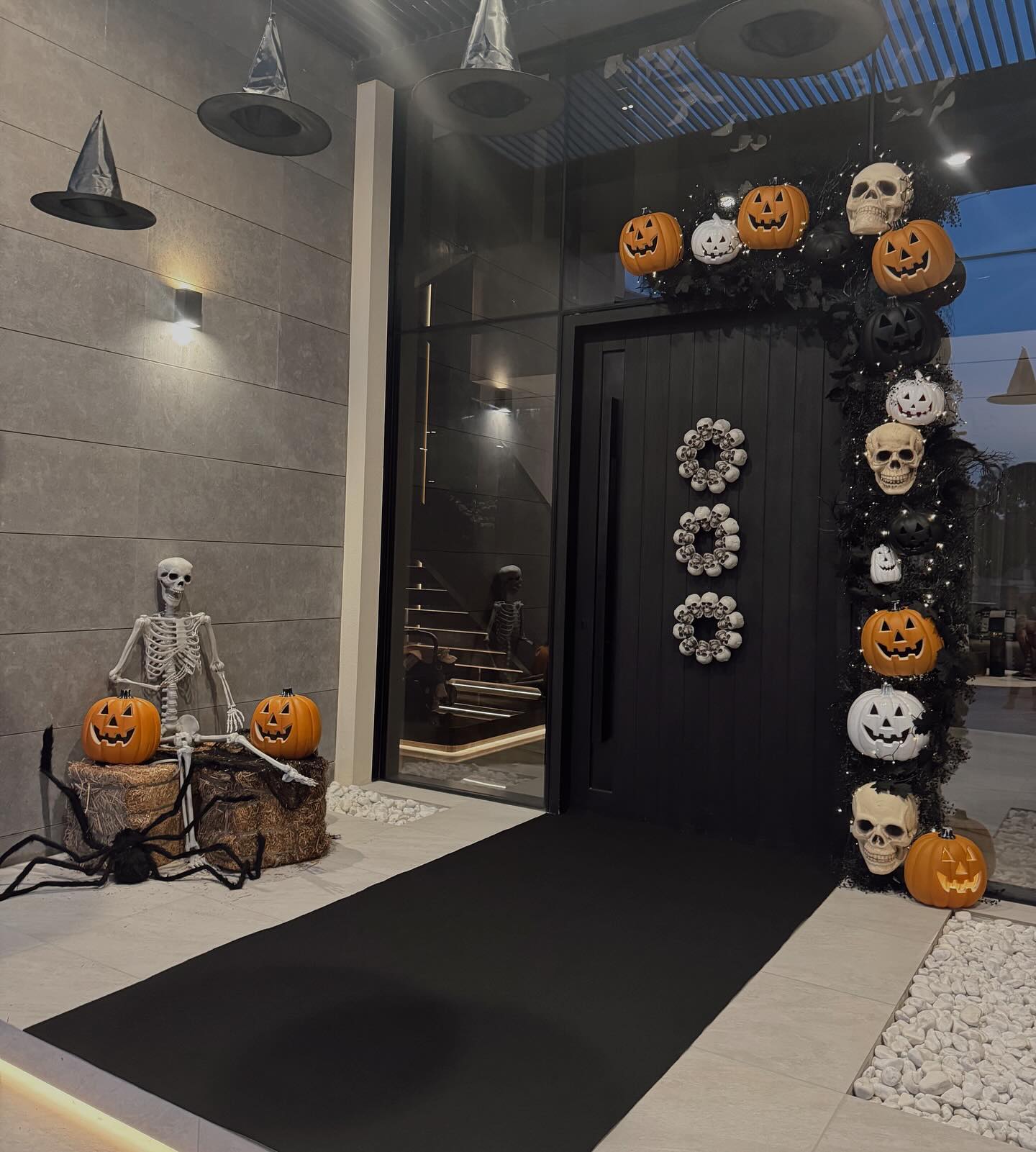 8. Spooky Silhouettes and Glowing Pumpkins Adorn a Webbed Front Door