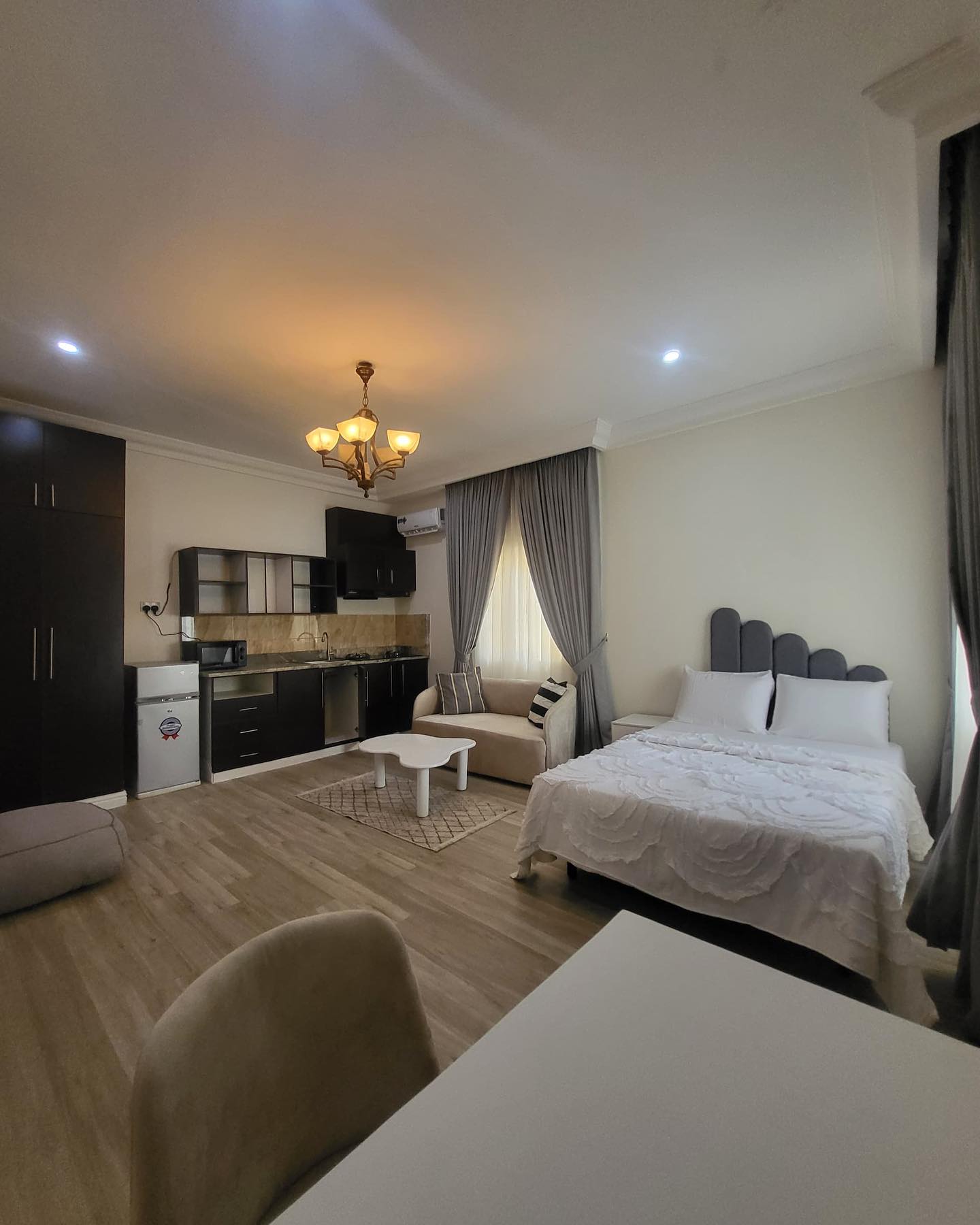 1. Compact Urban Oasis: a Monochrome Studio with a Suspended Bed and Exposed Brick Accent