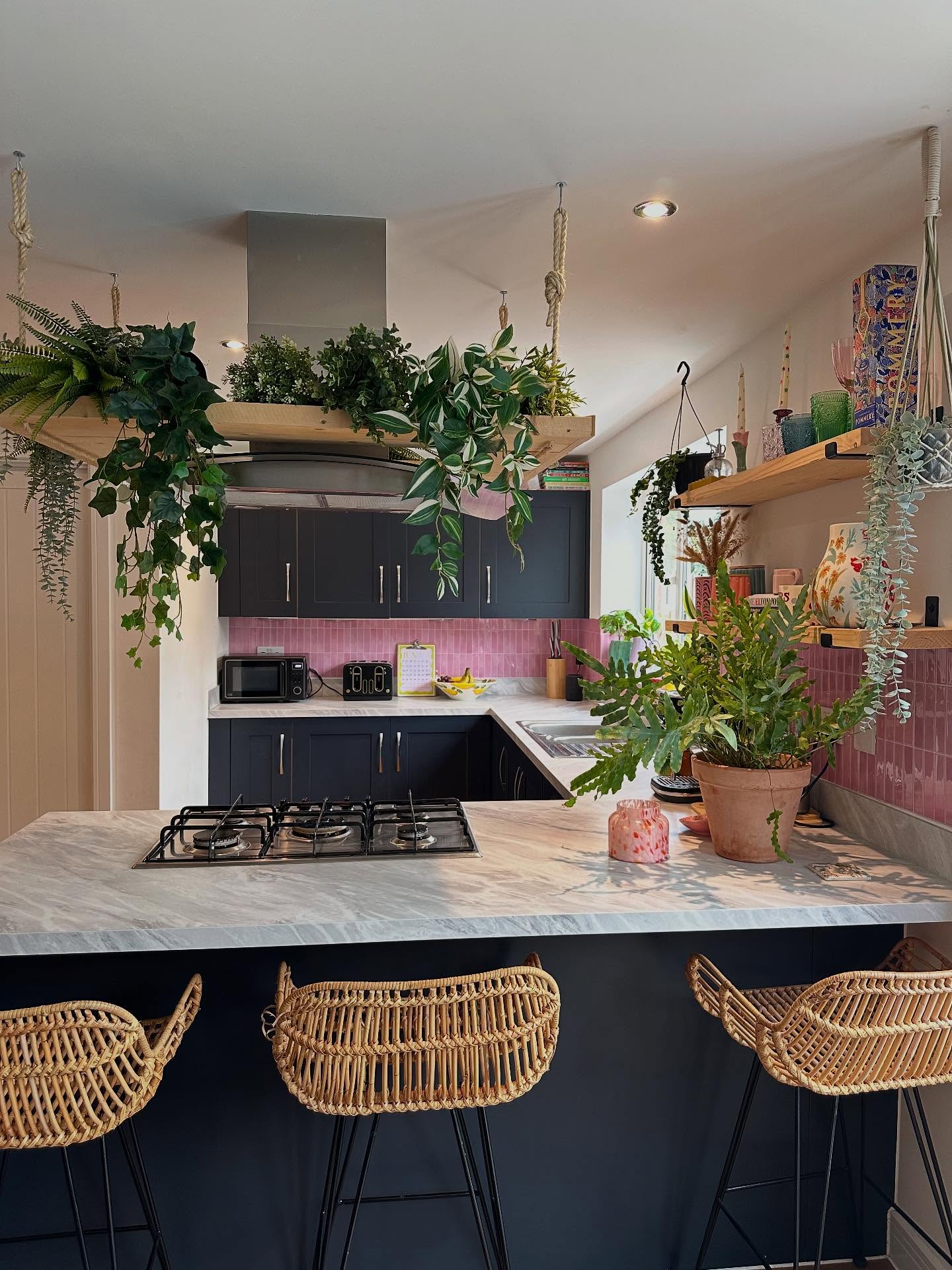 27. Whimsical Watermelon Pink Cabinets with Copper Accents and Open Shelving
