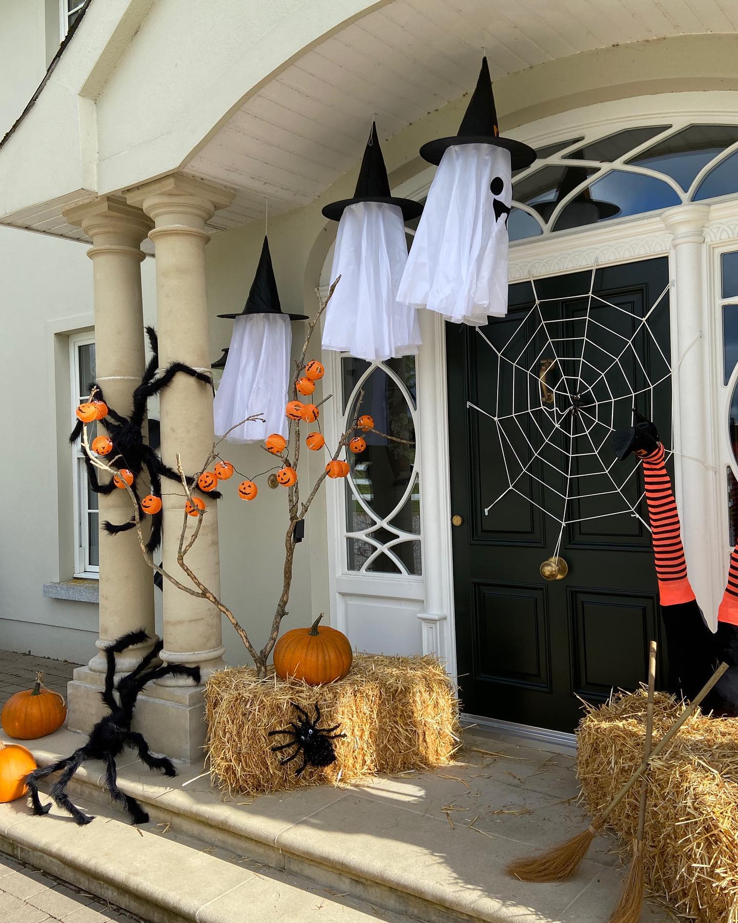 14. Spooky Spiderweb Silhouettes with Glowing Pumpkin Eyes on a Crimson Door