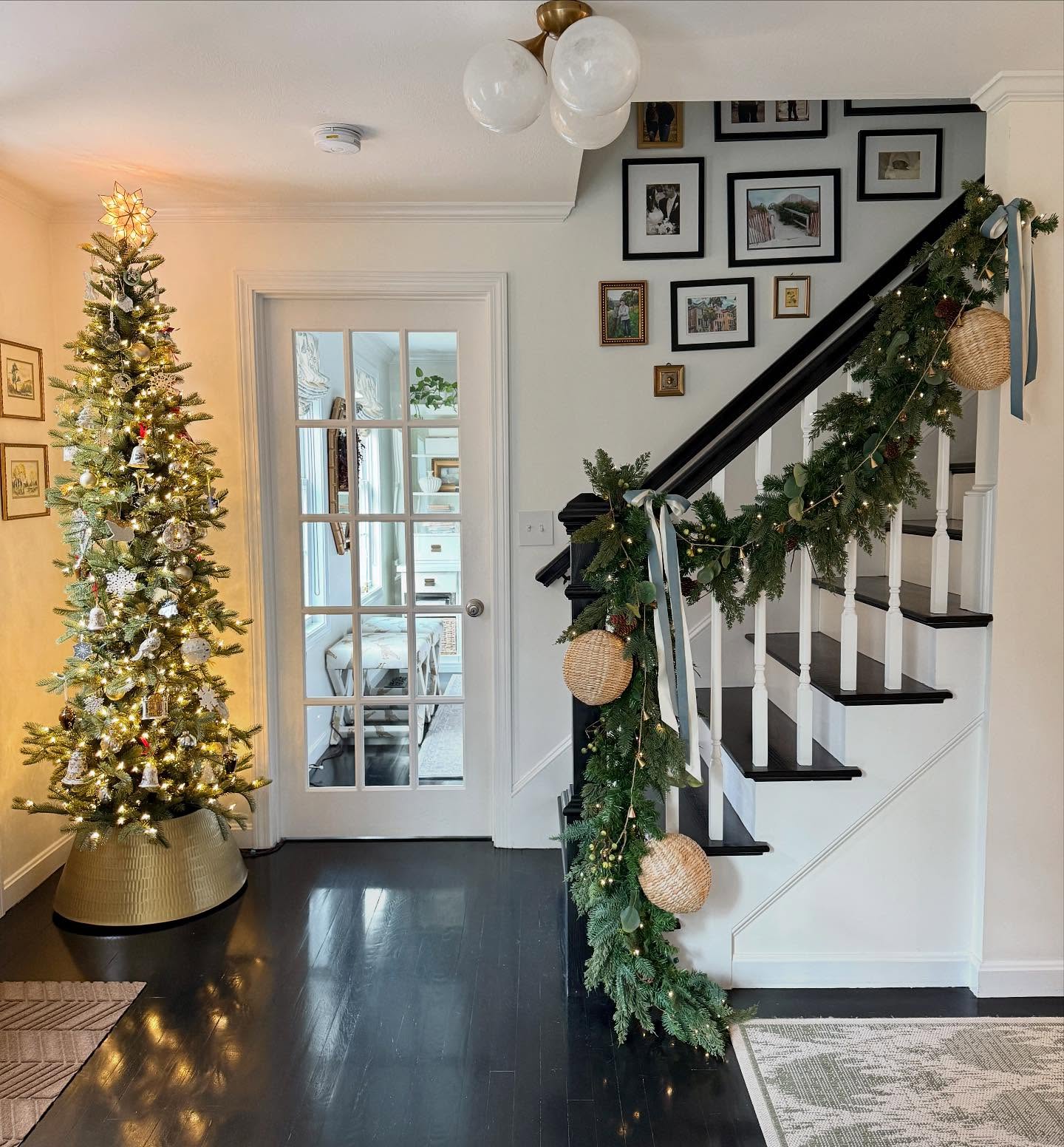 3. Twinkling Tinsel and Crimson Baubles Adorning a Glossy White Archway