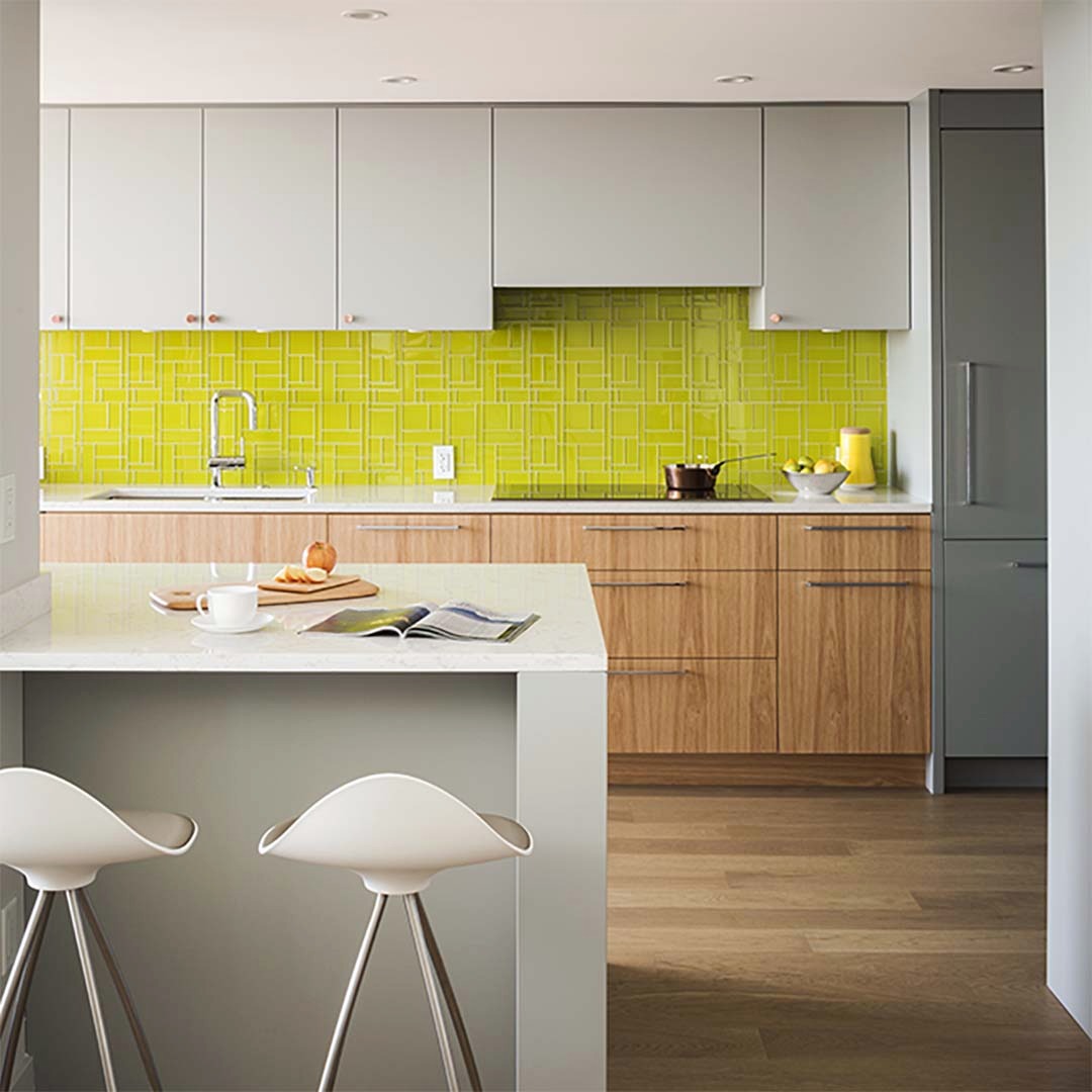 31. Vibrant Citrus Zest Tiles with Olive Branch Accents Against Warm Wooden Cabinets