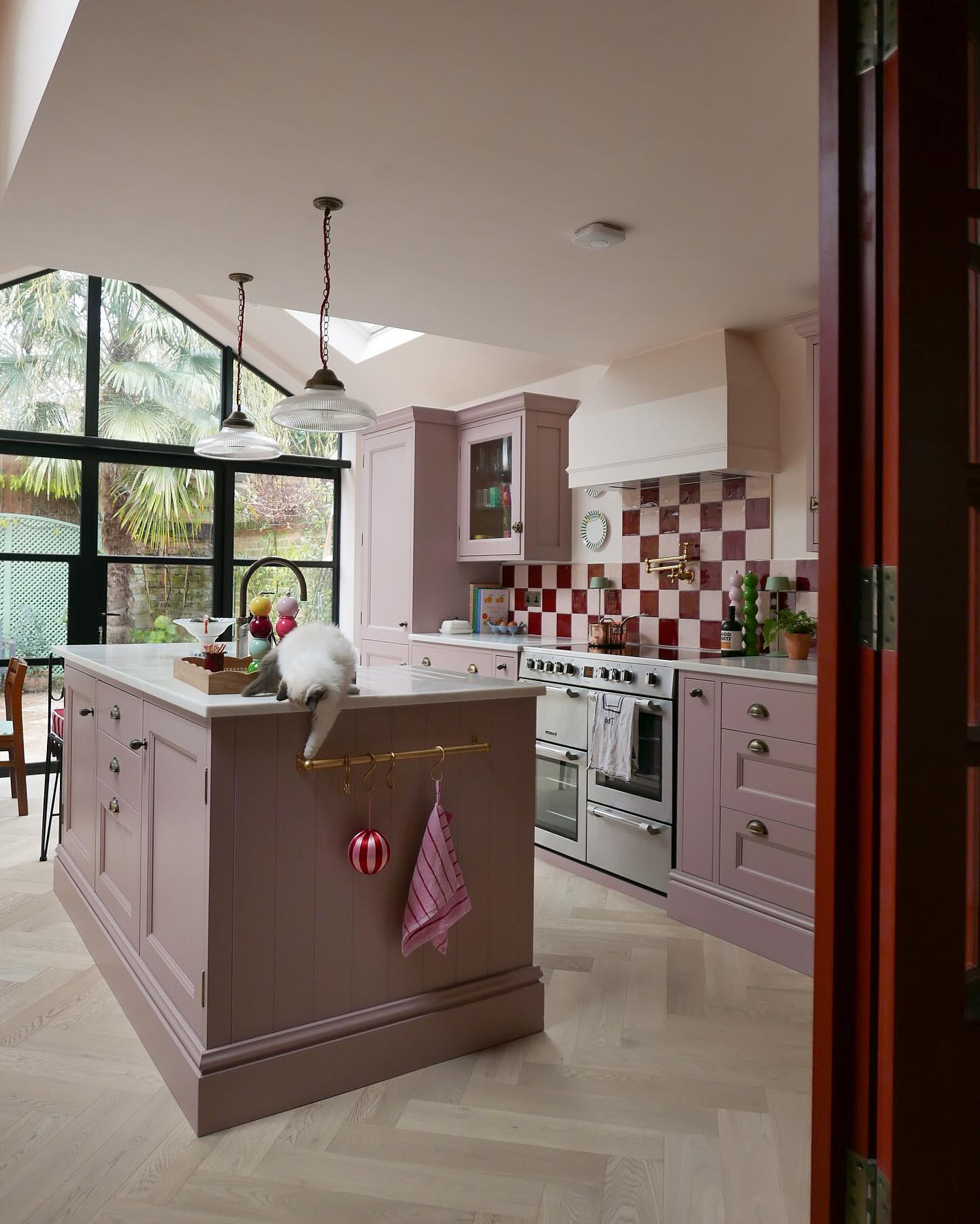 4. Bubblegum Pink Cabinets with Vintage Brass Hardware and Checkerboard Floor