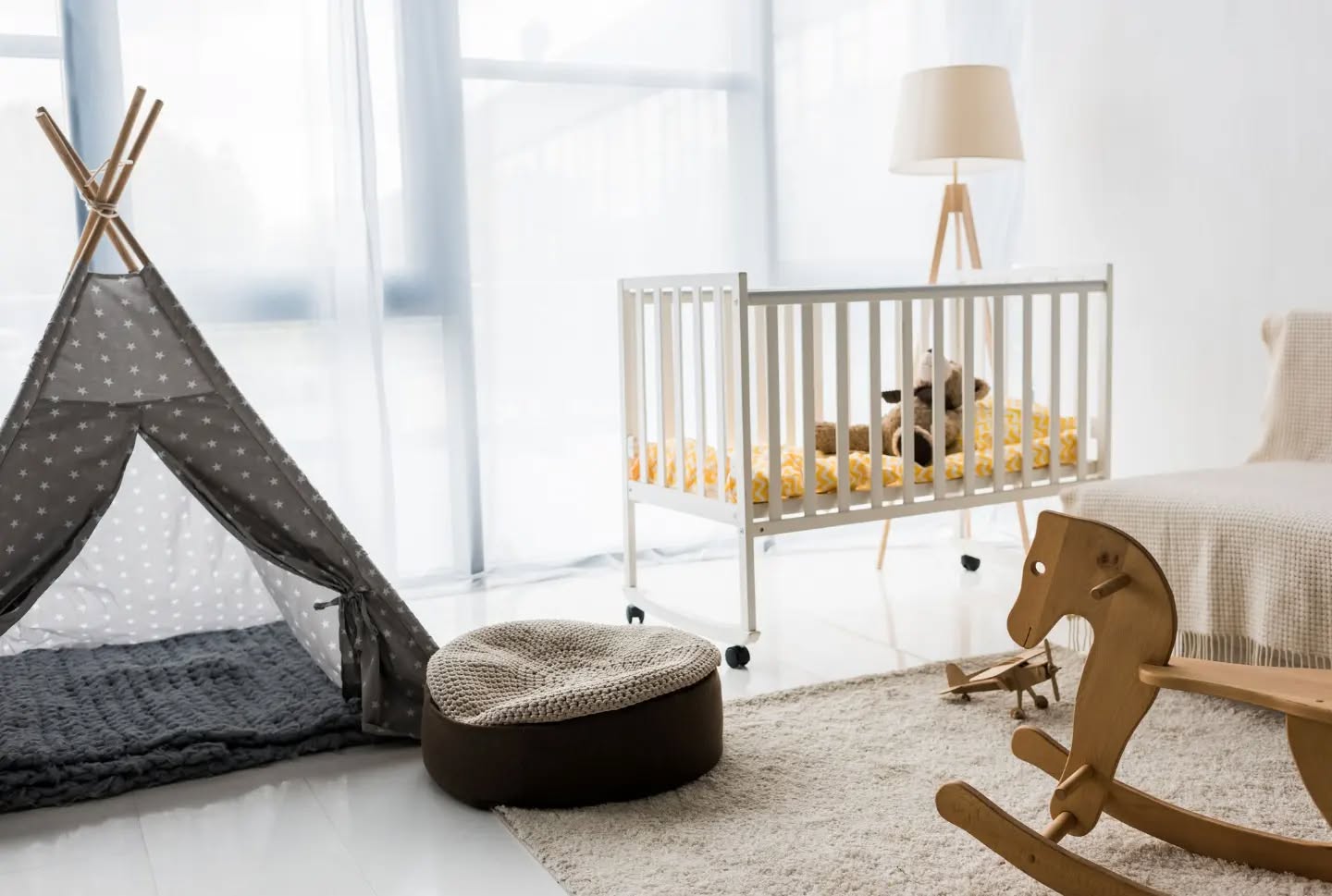 5. Soft Blush and Warm Wood: a Cribside Haven with Geometric Quilt