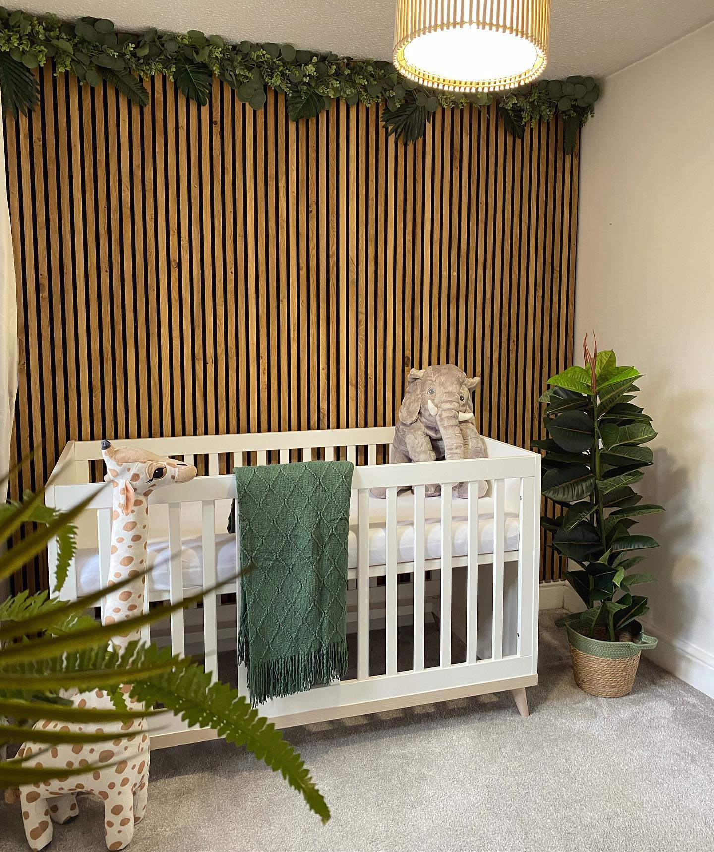 27. Sage Green Crib with Whimsical Cloud Mobile and Geometric Wall Patterns
