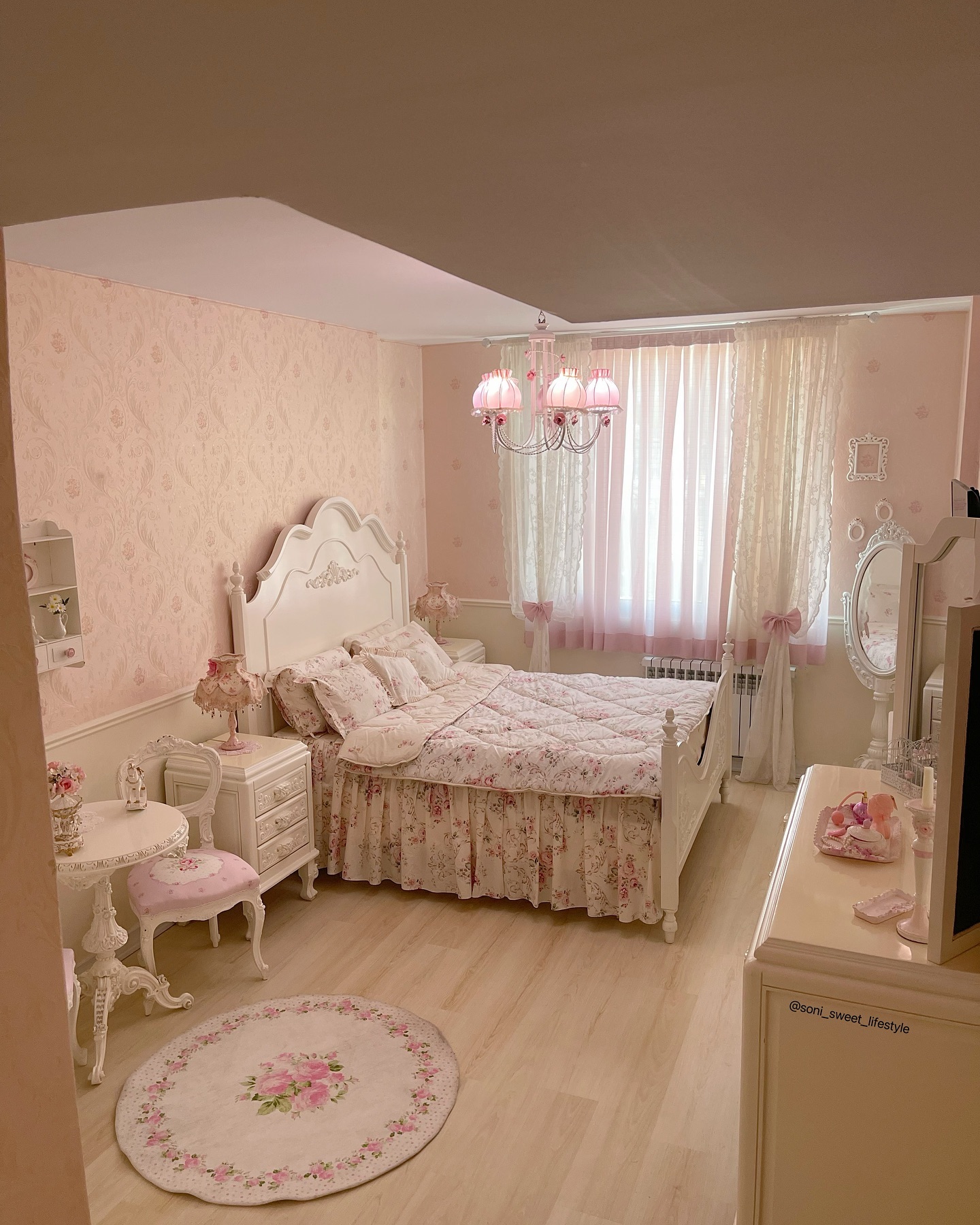 17. Soft Pink Canopy Bed with Floral Wall Accent and Vintage Lamps