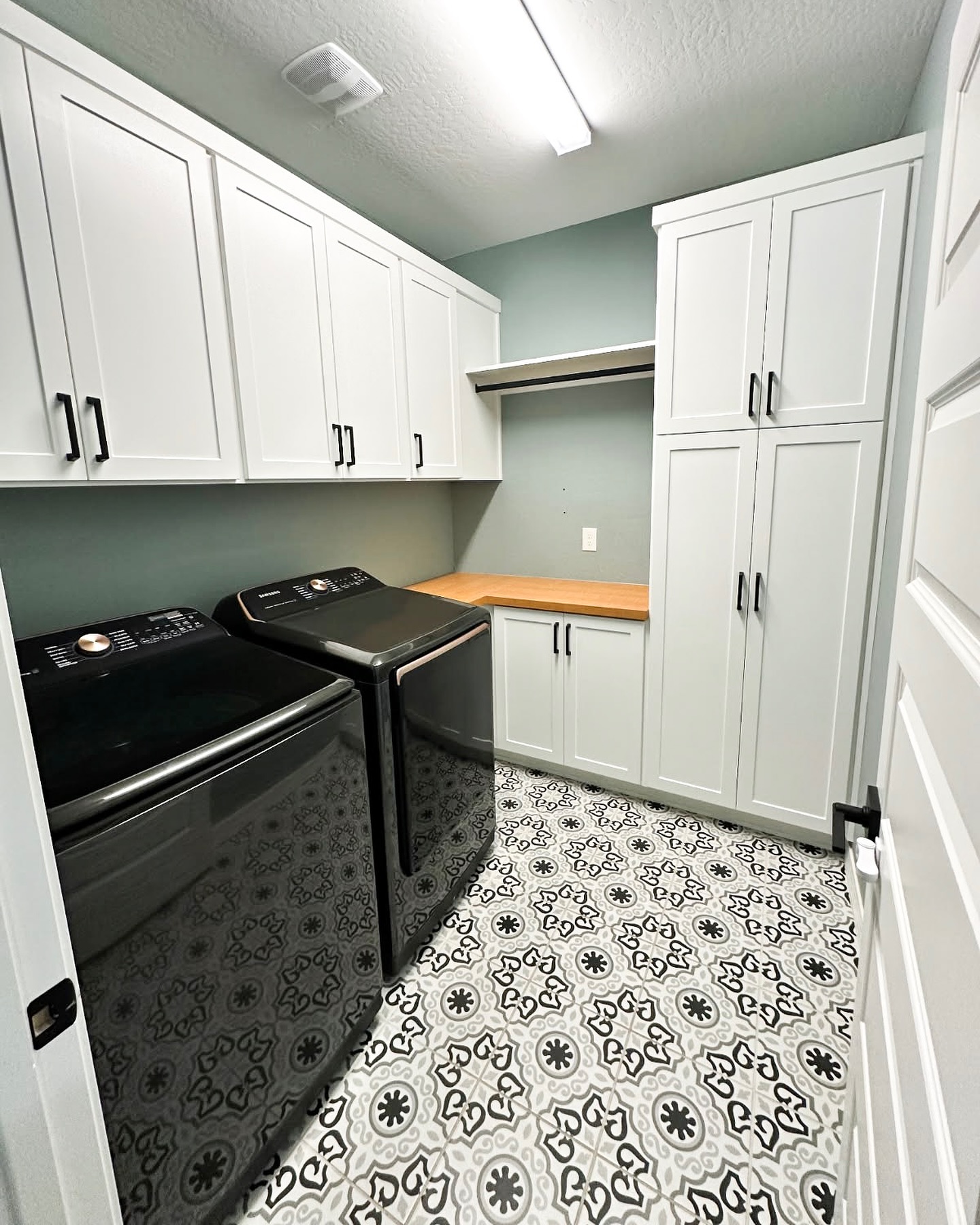 25. Moonlit Blue Shaker Cabinets with Brass Accents Illuminate a Compact Laundry Nook