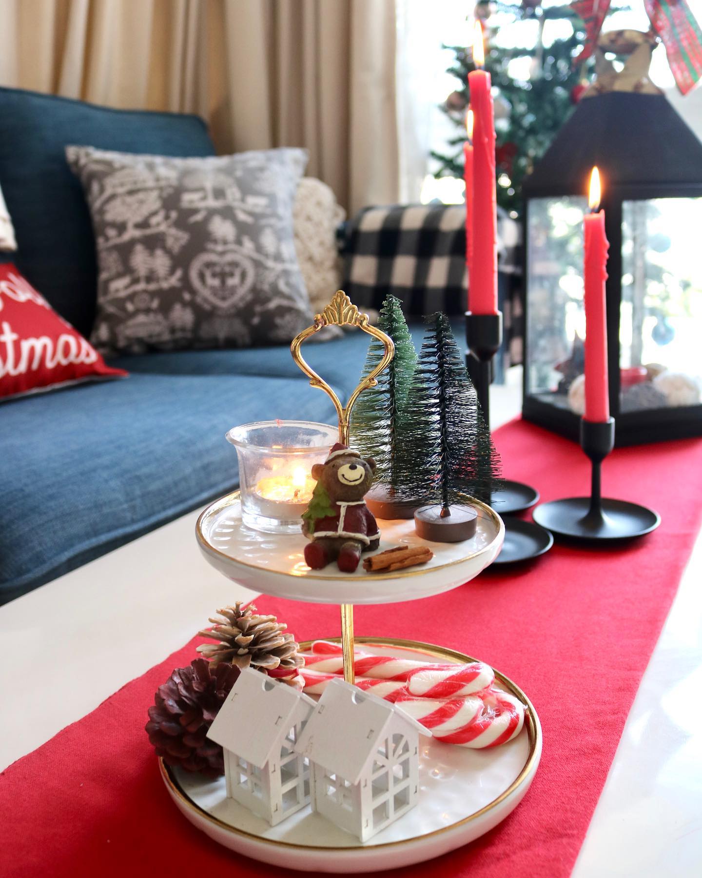 6. Frosted Pinecones and Metallic Ribbons Adorn a Rustic Wooden Sleigh on a Glass Coffee Table