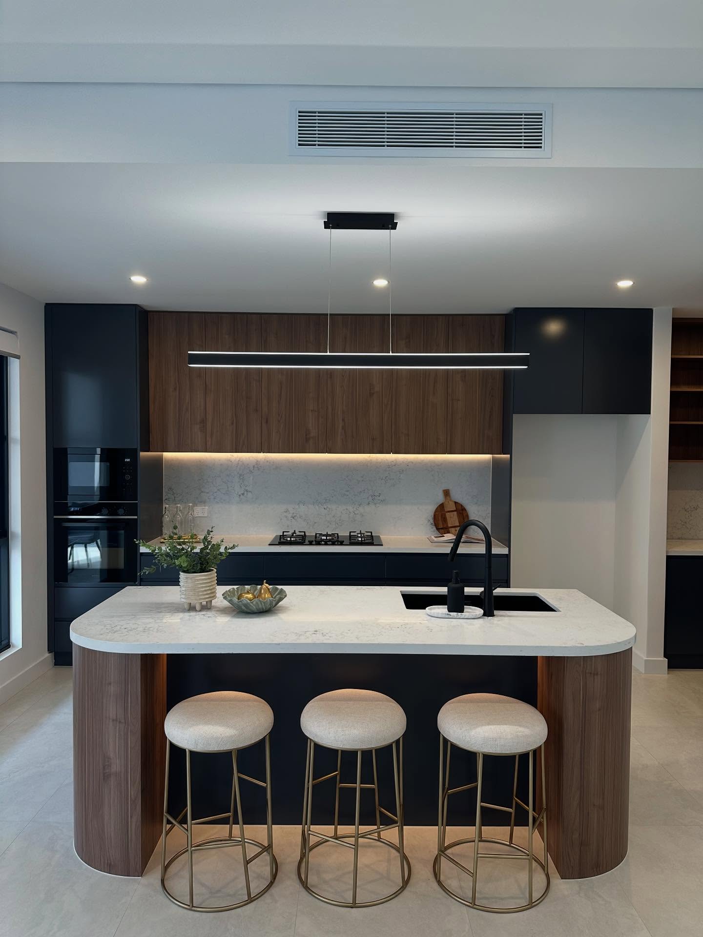 29. Cobalt Blue Cabinets with Brass Accents and Geometric Tile Backsplash