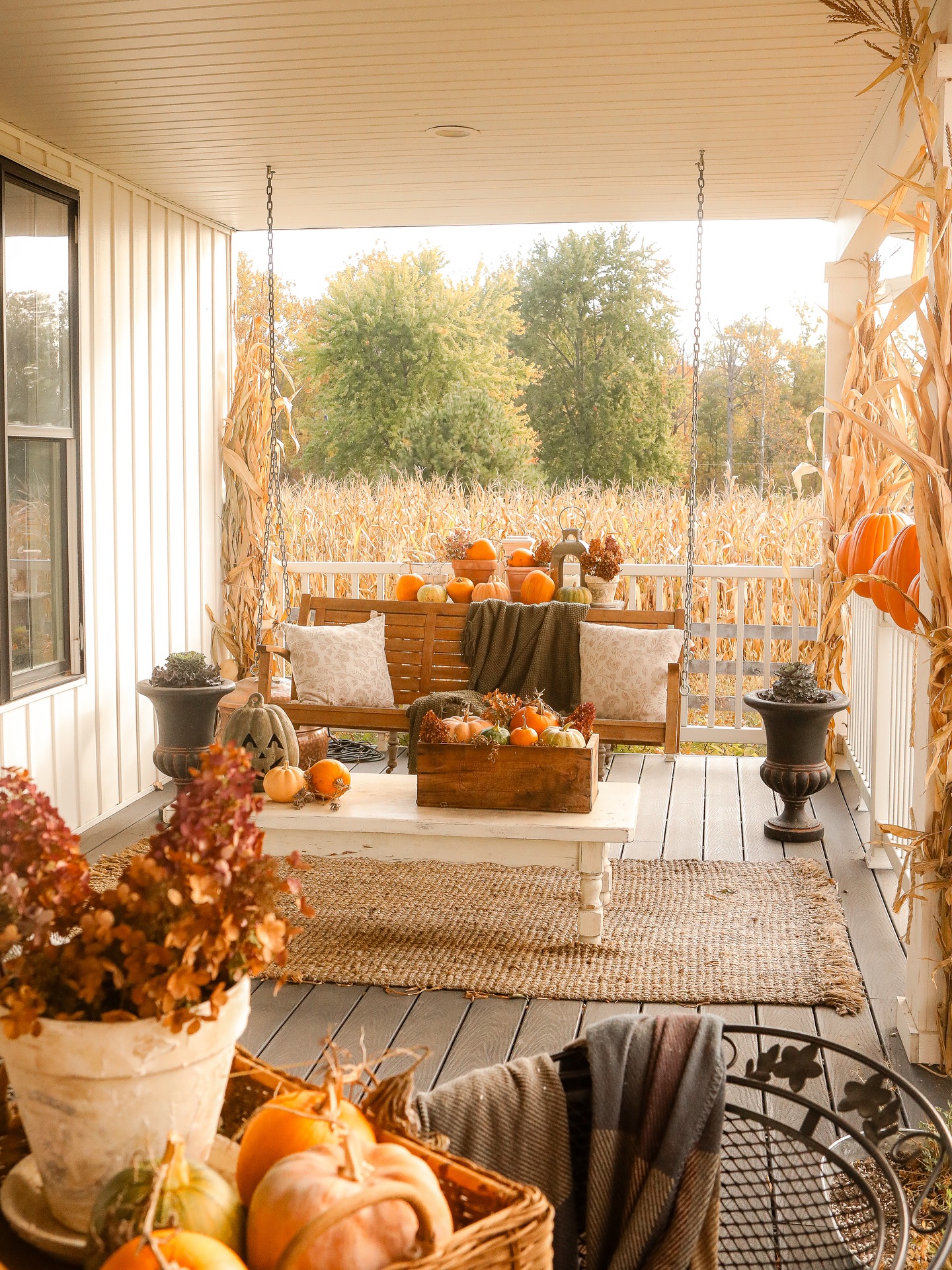 12. Woven Pumpkin and Berry Garland Draped Over Rustic Wooden Ladder