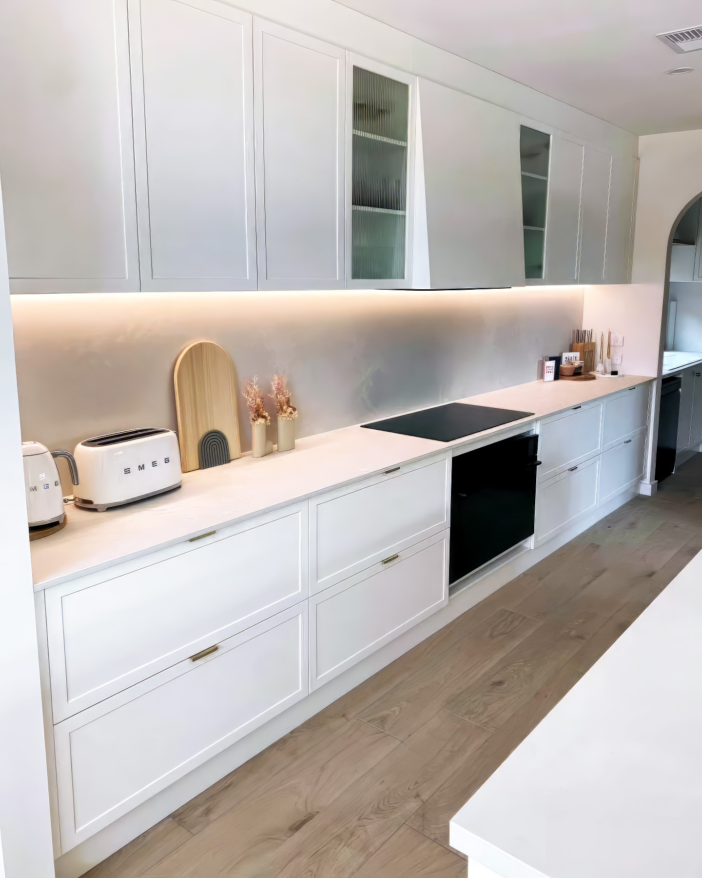 19. Frosted Glass Inserts and Crown Molding Accentuate This Crisp White Kitchen