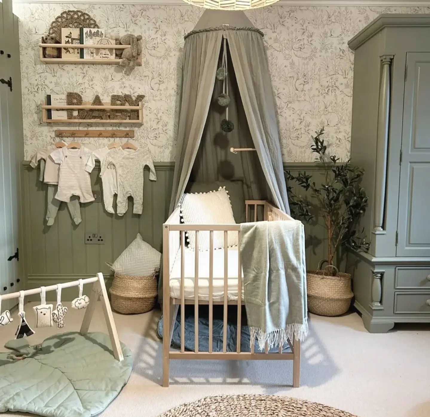 3. Sage Green Canopy Cradling a Whimsical Woodland Mobile