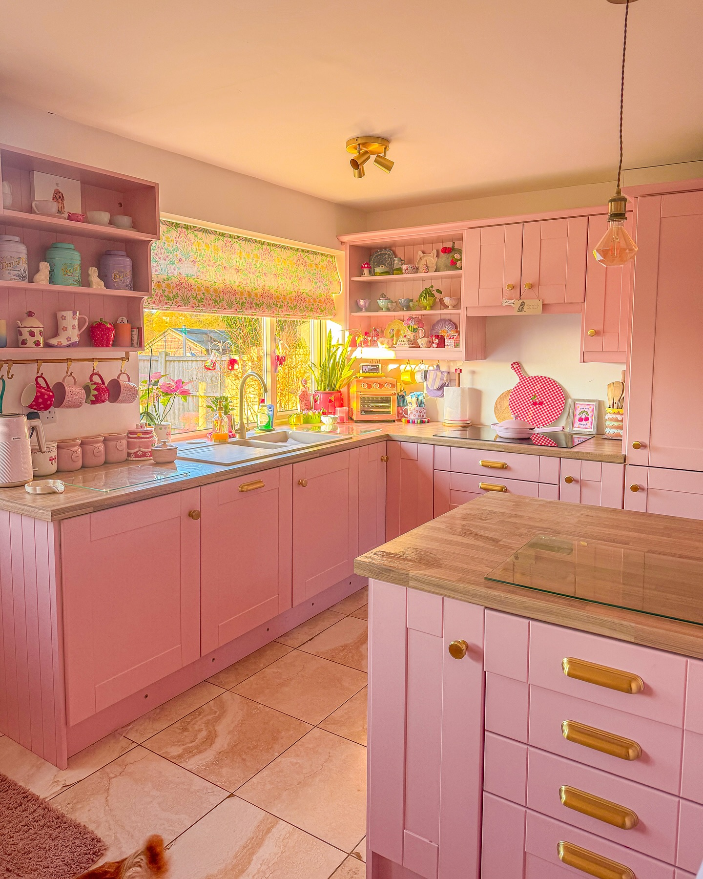 30. a Ballet Slipper Pink Island Amidst Glossy White Cabinets with Gold Accents