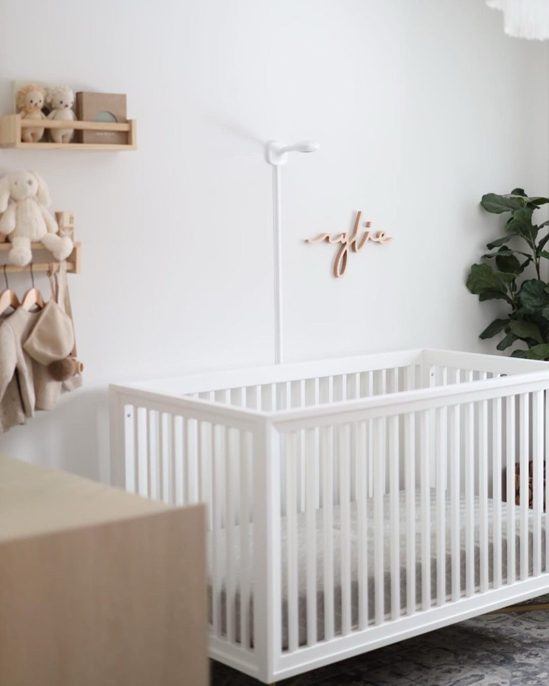 19. a Single White Mobile with Origami Cranes Hovering Over a Crib In a Soft Blue Room