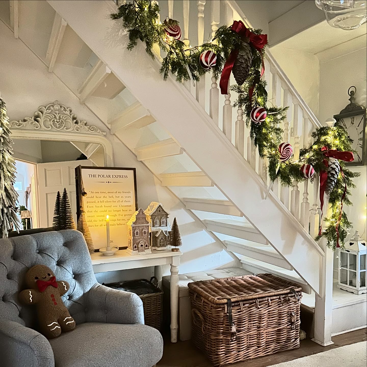22. Crimson Ribbons and Golden Pinecones Garland Weaving Through Festive White