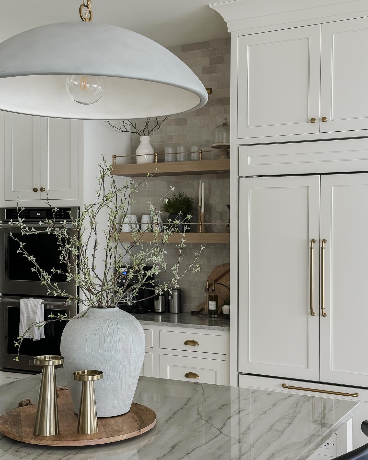 1. Crisp White Cabinets with Geometric Subway Tiles and Brass Hardware Accents